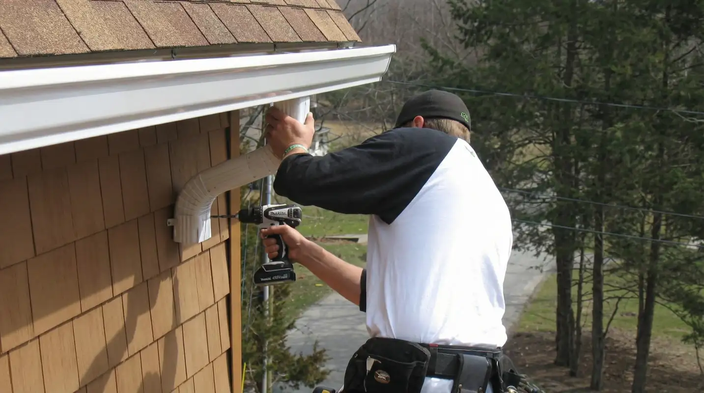 Professional contractor installing tan vinyl siding panels on a residential home exterior in Oklahoma City, OK